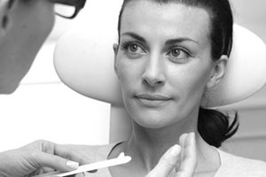 Un dermatologue applique une crème sur le visage d’un patient