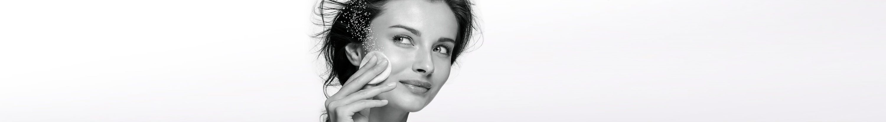 Femme se nettoyant le visage avec un coton