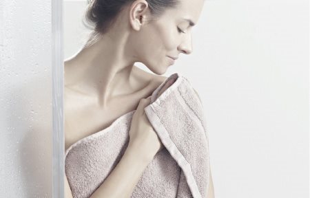 Femme qui se tapote la peau après la douche pour la sécher.