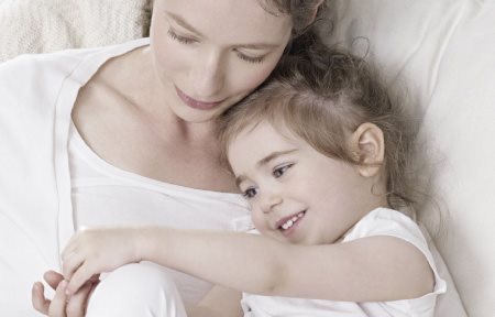 Mère et enfant assis côte à côte qui se font des câlins.
