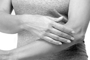 Femme se touchant le bras gauche