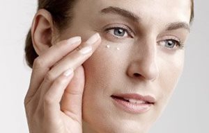 Woman applies eye cream