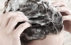 Femme se massant le cuir chevelu pendant son shampoing