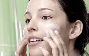 Femme utilisant un Gel Nettoyant sur les joues