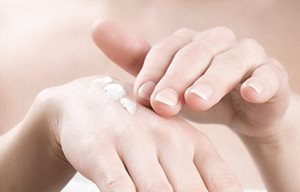 Femme appliquant la crème mains