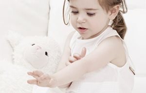 Petite fille qui joue avec un animal en peluche.