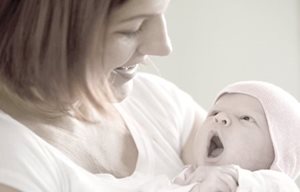 Femme qui tient un nourrisson dans ses bras.