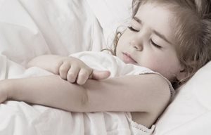 Une petite fille se gratte le pli du coude.