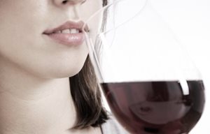 Femme buvant un verre de vin rouge.