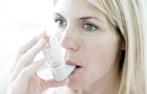 Femme utilisant un inhalateur.