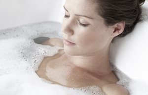 Femme qui se détend dans un bain moussant