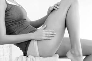 Femme appliquant un produit Eucerin sur sa jambe