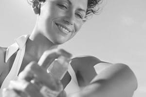 Femme s'appliquant de l'écran solaire sur le bras